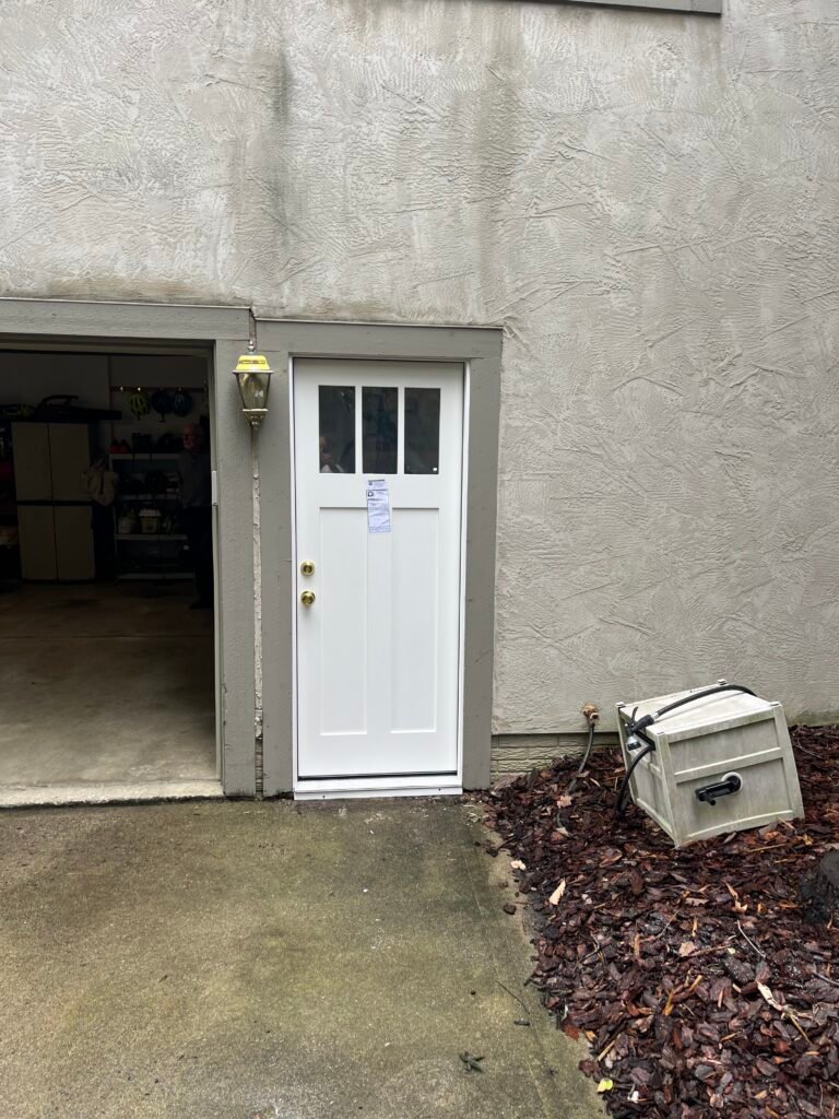 White JELD-WEN entry door with three upper windows beside an open garage